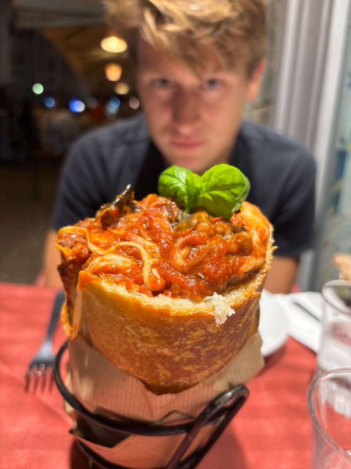 Un piatto della tradizione con basilico fresco in primo piano.