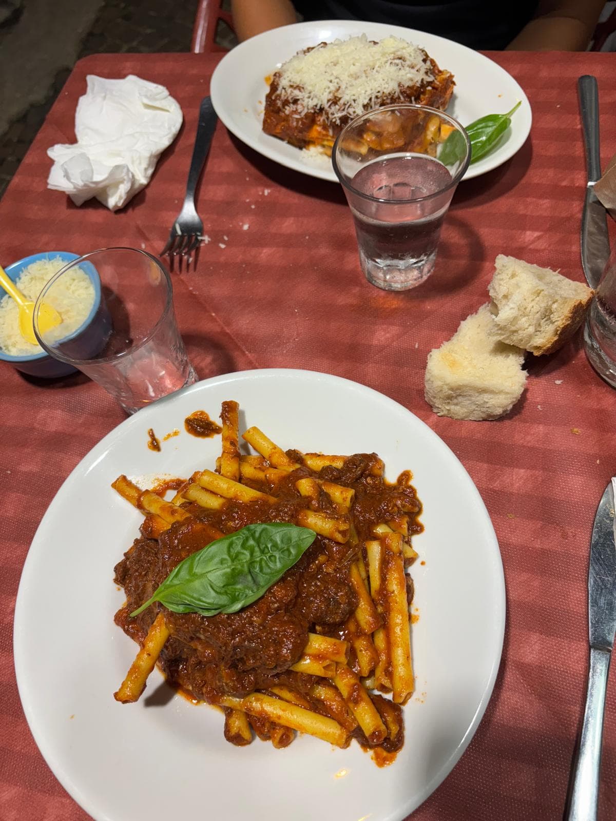 Pasta e parmigiana sulla tovaglia rossa: la tavola della domenica.