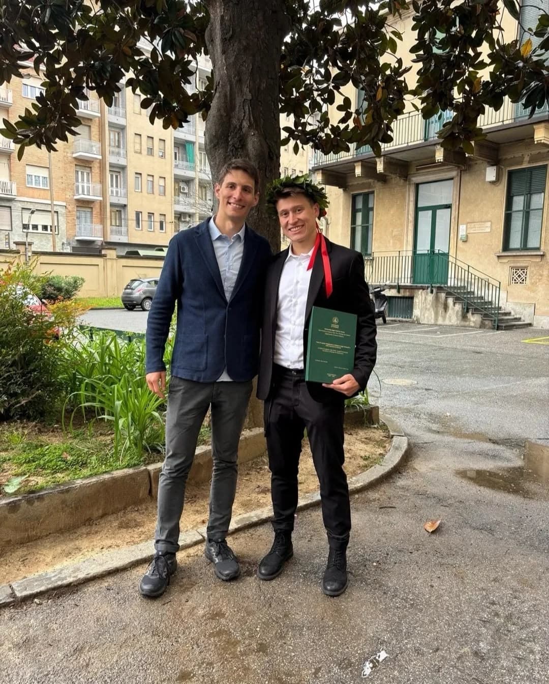 Marco con la pergamena il giorno di laurea, insieme a un amico.